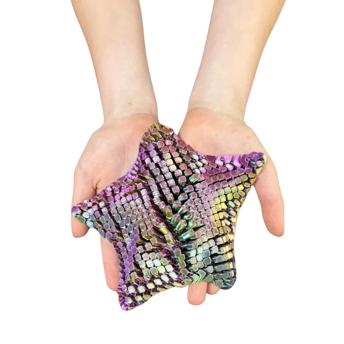 Hands holding a 5-pointed iridescent purple and green star fidget made of small, geometric 3D-printed segments.