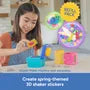 A girl uses a small blue machine to create colorful garden-themed 3D shaker stickers like a snail and a flower.