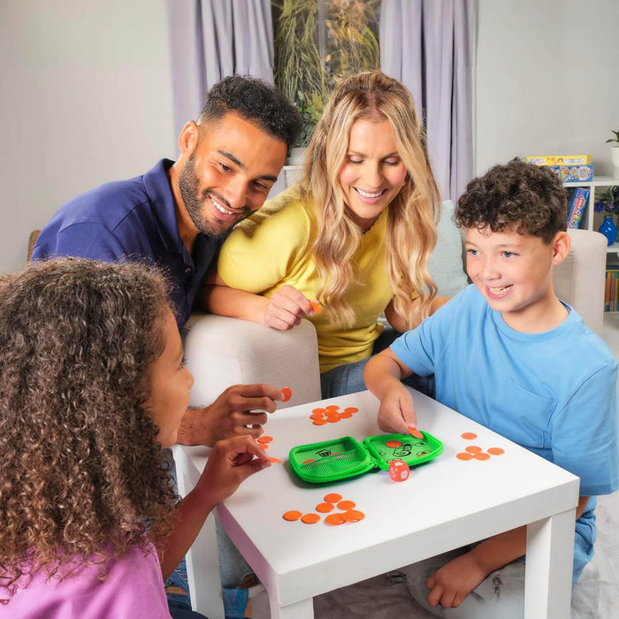 Family playing a dice game with a green zippered case, orange tokens, and an orange die on a white table.