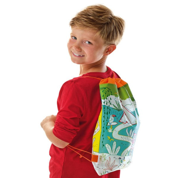 A smiling boy wearing a drawstring backpack featuring a colorful jungle scene with animals and tropical plants.