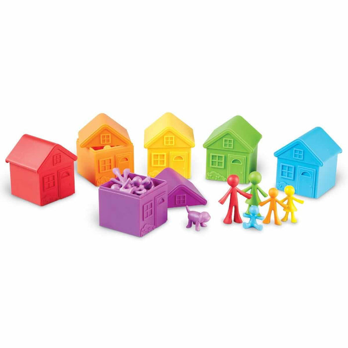 Six rainbow-colored toy houses with removable roofs and matching family and pet figures on a white background.