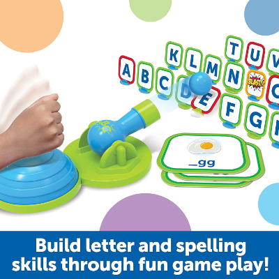 Child hits blue air pump to launch ball from a cannon at colorful alphabet targets and word cards.
