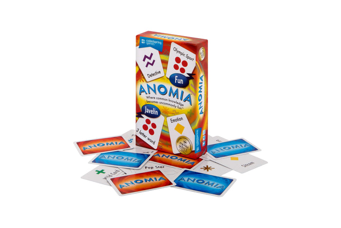 Brightly colored Anomia game box surrounded by scattered cards with symbols and words like Sitcom and Pop Star.