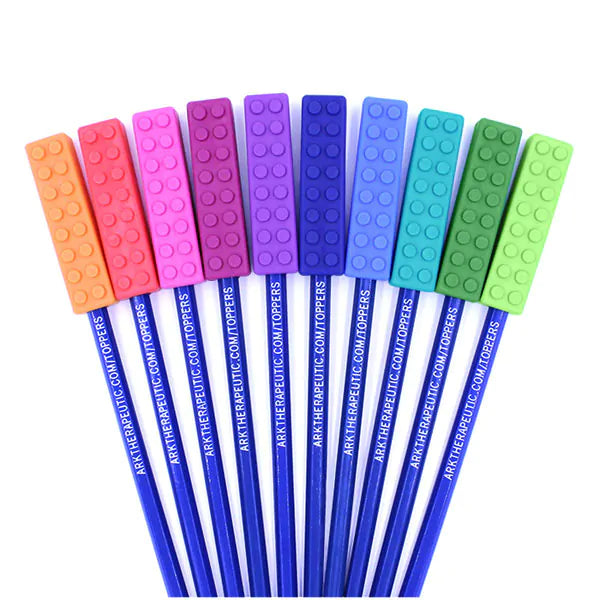 Ten colorful, textured, brick-shaped chewable pencil toppers fanned out on blue pencils.