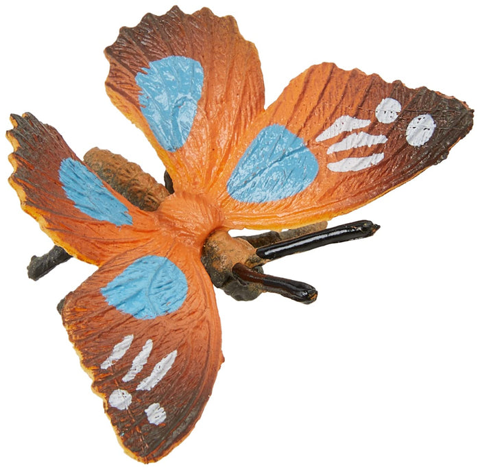 Orange toy butterfly with four large blue spots, white wing markings, and black antennae.