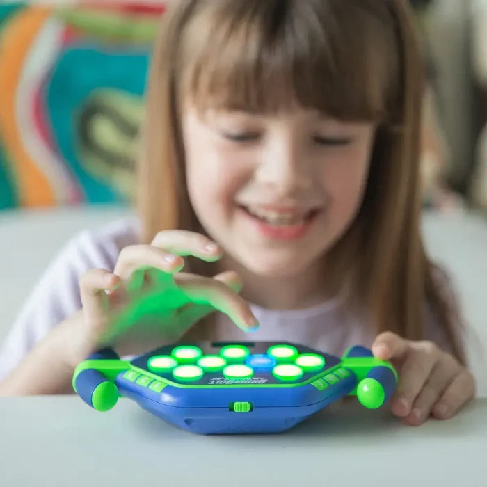 Smiling girl playing a blue and green handheld game with eight glowing green circular buttons.
