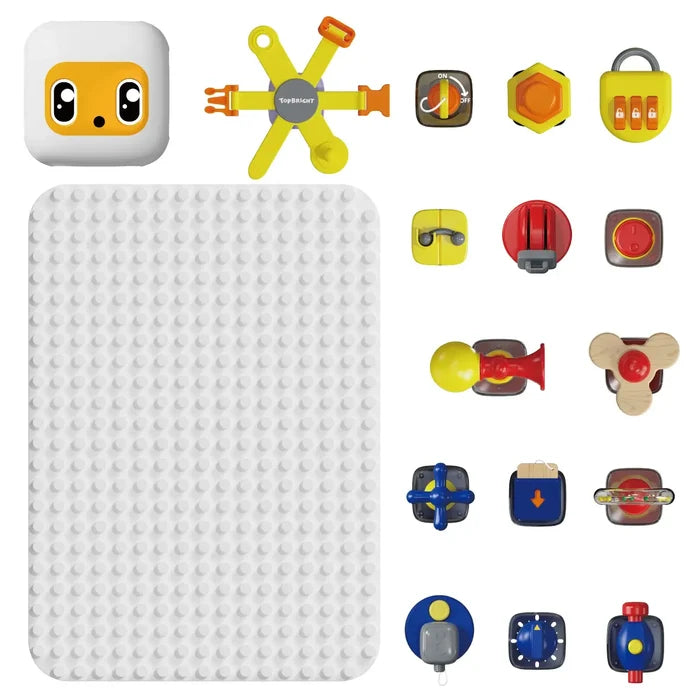 White studded baseboard with colorful interactive toy parts like a yellow robot face, locks, dials, and a horn.