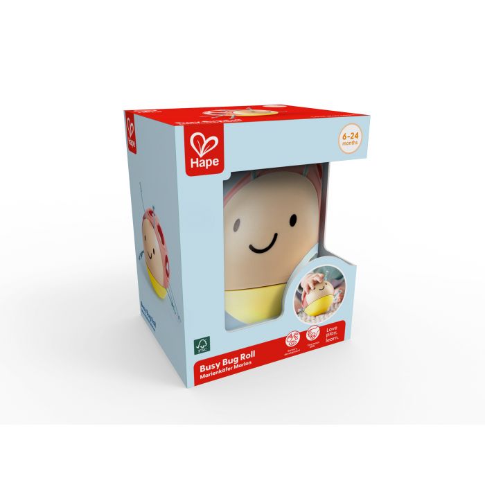 A smiling Hape ladybug rolling toy inside a light blue and red window box showing a 6-24 months age range.