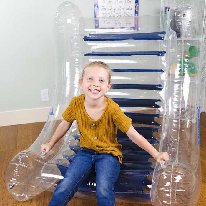 Smiling girl sitting inside a transparent inflatable rocker with blue horizontal interior bands and side handles.