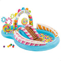 Blue inflatable pool with candy graphics, chocolate slide, peppermint stripes, lollipops, and a spraying arch.