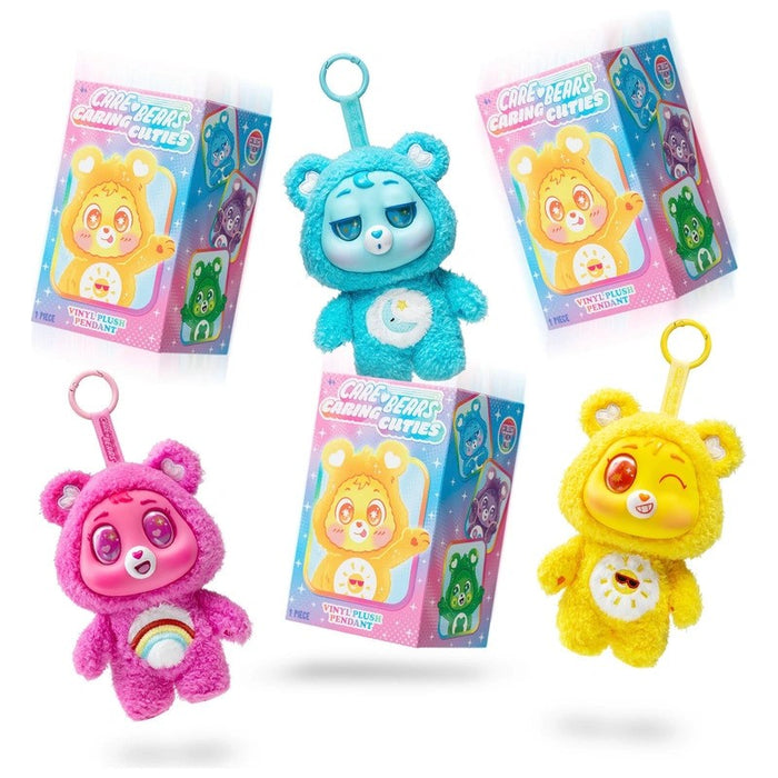 Pink, blue, and yellow furry Care Bear plush keychains with vinyl faces and plastic clips next to mystery boxes.