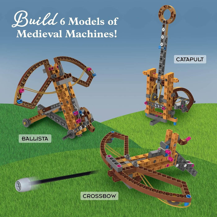 Three tan and brown plastic models of a ballista, catapult, and crossbow on a green grass and blue sky background.