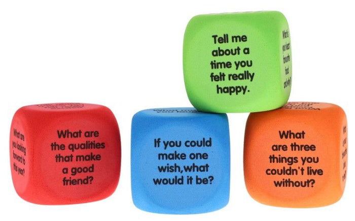 Four colorful foam dice in red, blue, orange, and green with printed conversation starter questions on each face.