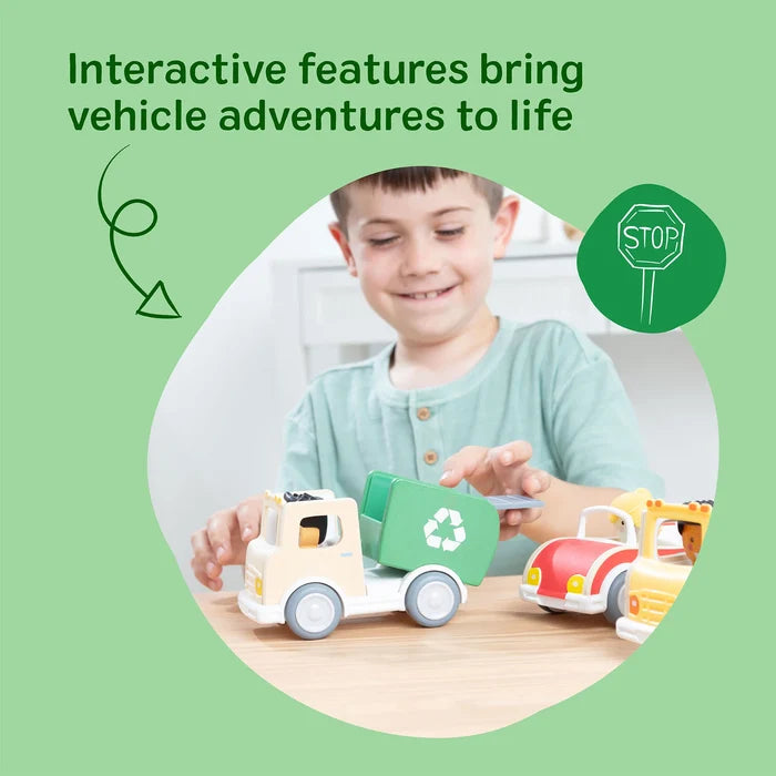 A boy playing with a wooden green recycling truck and red car. The truck has a tilting back and recycling symbol.