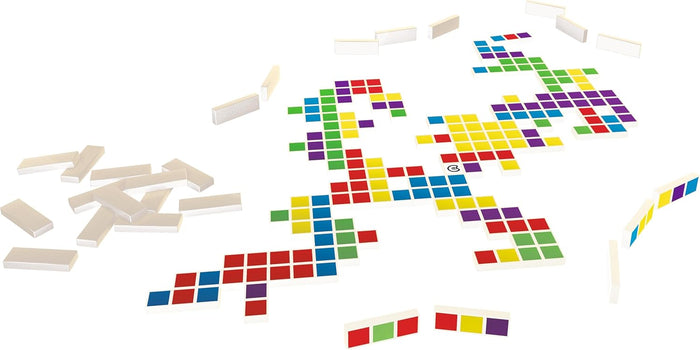 Rectangular game tiles with three colored squares arranged in a sprawling pattern on a white surface with spare pieces.
