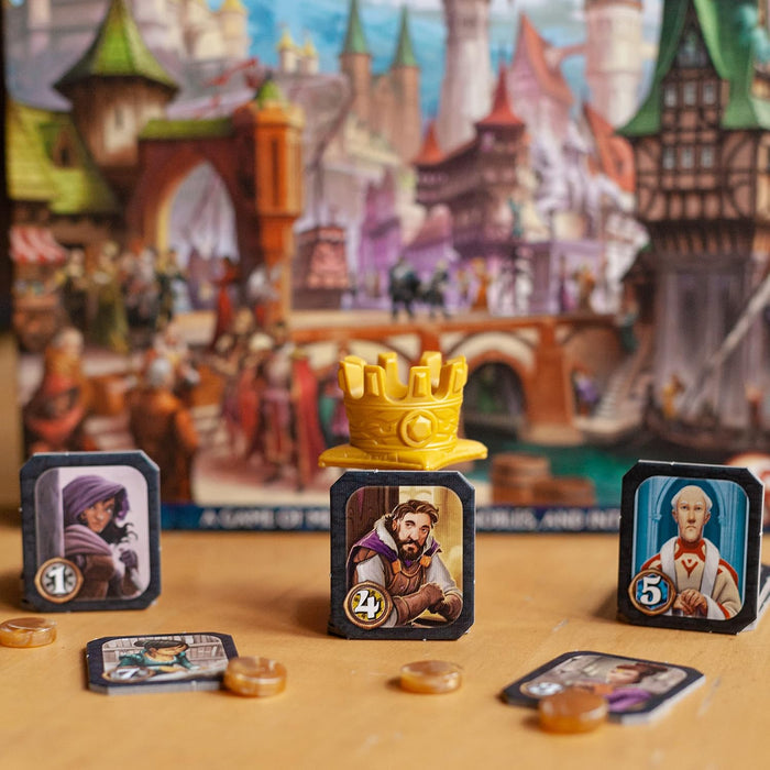 Character tiles and a yellow crown token from Citadels displayed against a colorful medieval city background.