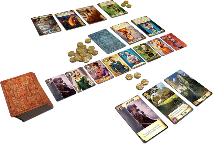 Fantasy card game setup with illustrated character and building cards, gold coins, and a thick brown card deck.