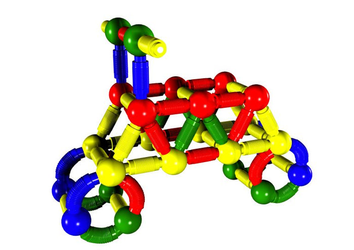 Colorful toy tricycle built from red, yellow, blue, and green jumbo magnetic rods and spherical connectors.
