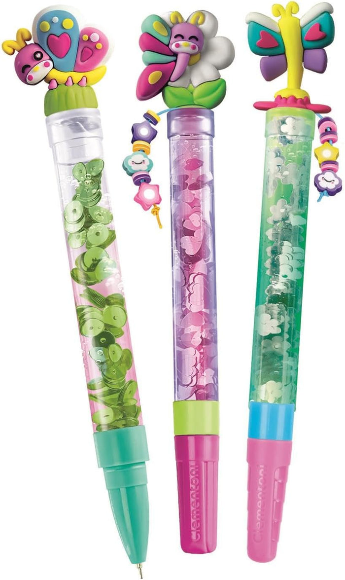 Three colorful pens with butterfly and flower toppers, liquid-filled barrels with sequins, and beaded charms.