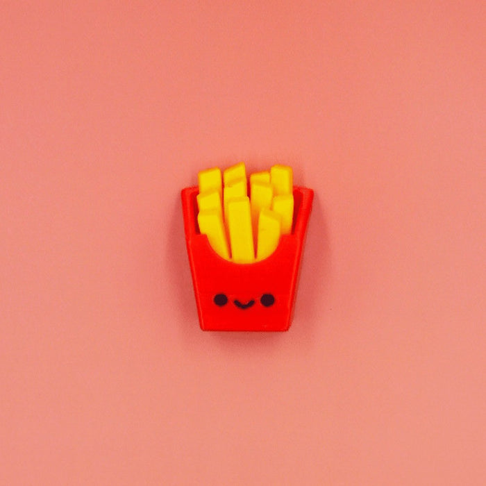 Red French fry container fidget with yellow fries and a cute smiley face, centered on a solid pink background.