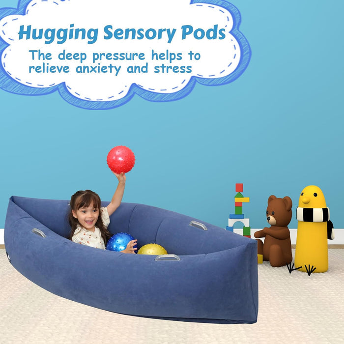Child playing in a blue boat-shaped inflatable sensory pod with colorful textured balls on a white carpet.