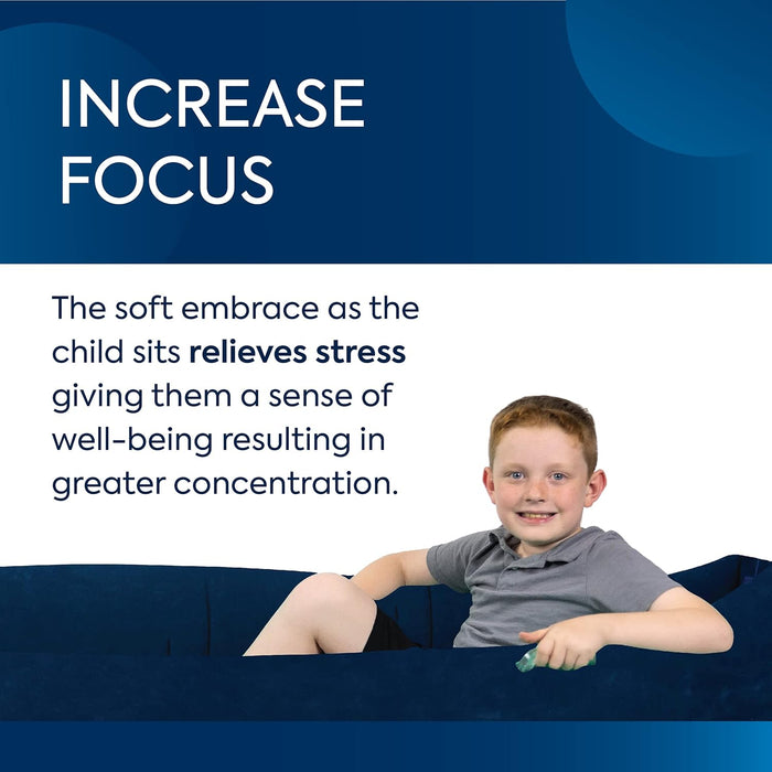 A young boy sitting inside a deep navy blue inflatable sensory pod with high walls.
