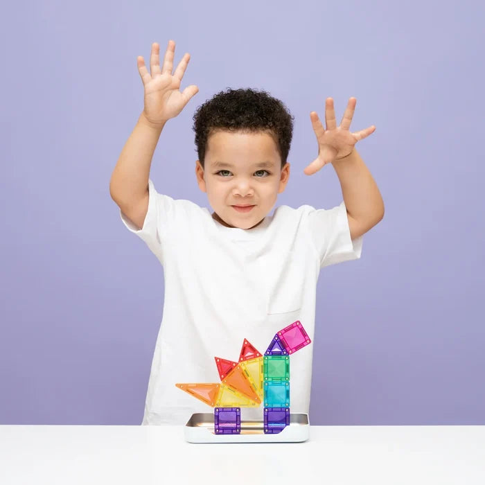 A boy with a rainbow magnetic tile dinosaur made of translucent triangles and squares on a purple background.