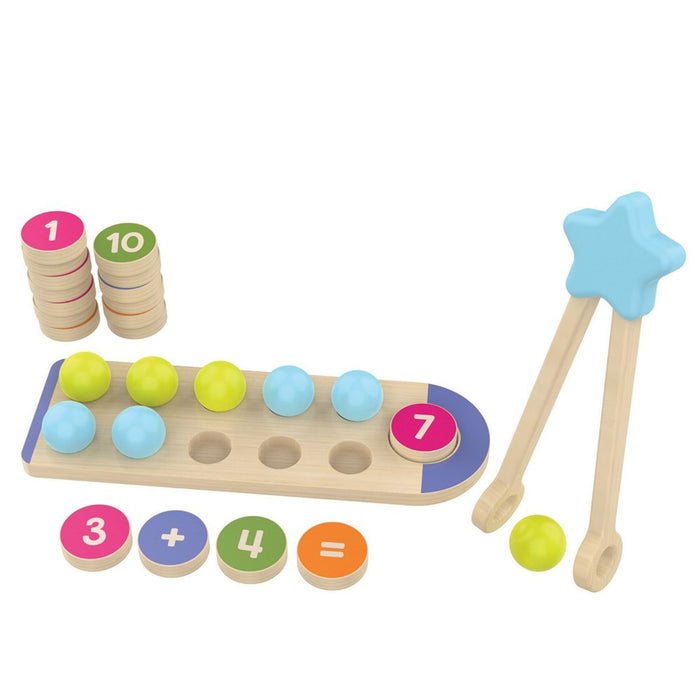 Wooden toy set with star tongs, blue and green balls, and numbered tokens showing a 3 + 4 = 7 math equation.