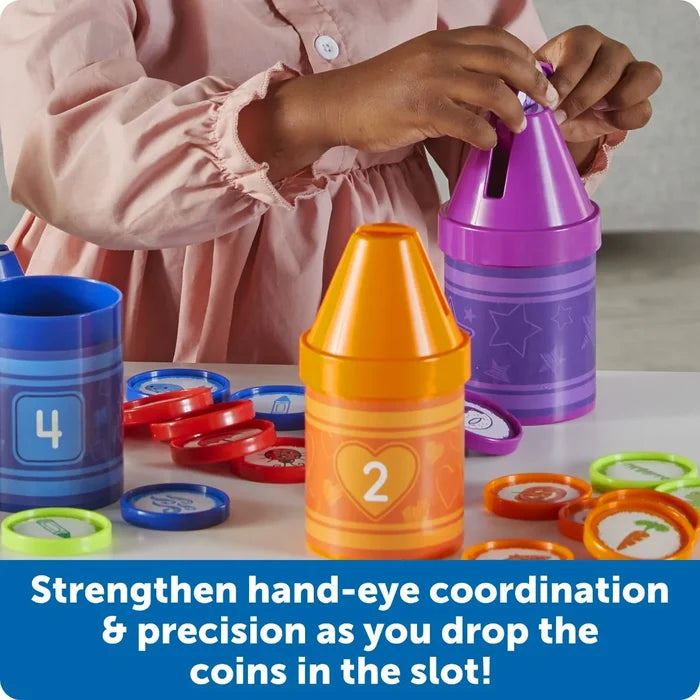 Child drops colorful picture discs into slots on blue, orange, and purple crayon-shaped sorting containers.