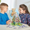 A boy and girl play a 3D mountain board game with colorful illustrated paths and footprint tokens on a table.