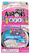 Clear putty tin filled with colorful beads and smiley faces. Includes two interlocking cat-shaped friendship charms.