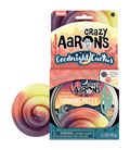 Swirled glittery putty in purple, peach, and yellow next to its desert-themed metal tin and cardboard package.