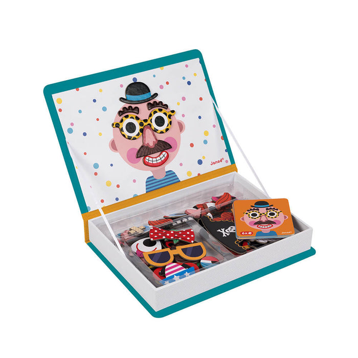 Open teal book-shaped magnetic toy with a funny face on the lid and various magnetic pieces in a storage tray.