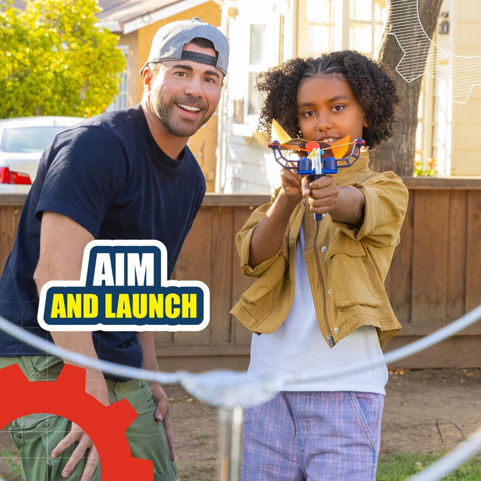 Smiling man and girl outside. Girl aims a blue toy launcher with an orange plane. Text: Aim and Launch.