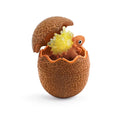 Orange toy dinosaur with spiky yellow crystals on its back, sitting inside a cracked, textured brown egg.