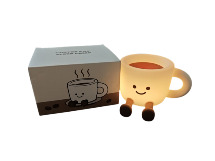 Warm glowing smiley coffee cup lamp with legs next to its white and brown illustrated packaging box.