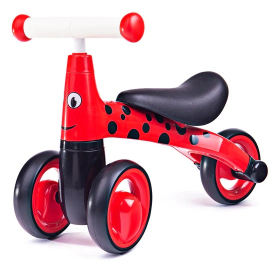 Red ladybird-themed toddler ride-on trike with black spots, a cartoon face, white handlebars, and a black seat.