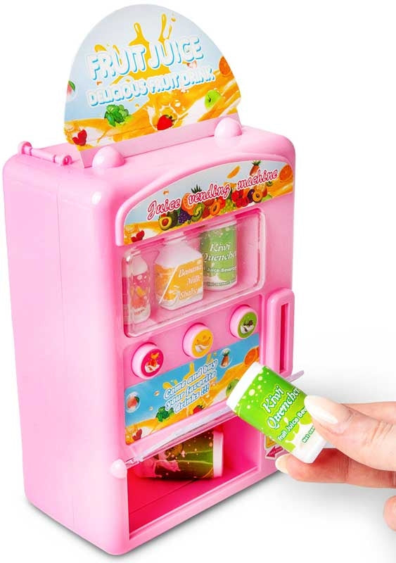 Pink toy juice vending machine with a clear window and a hand holding a small dispensed green drink bottle.