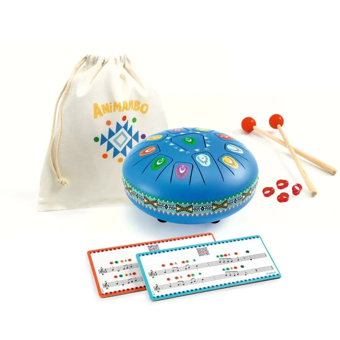 Blue metal tongue drum with colorful icons, wooden mallets, white canvas bag, and color-coded music cards.