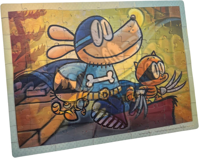 Completed 100-piece jigsaw puzzle of Dog Man in a blue suit and a small orange cat against a vibrant yellow sunset.