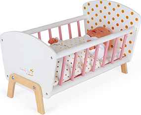 White wooden doll crib with pink bars, yellow polka-dot details, and a baby doll sleeping inside.