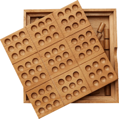 Light brown wooden board with a 9x9 grid of circular holes, resting on an open box containing small cylindrical pegs.