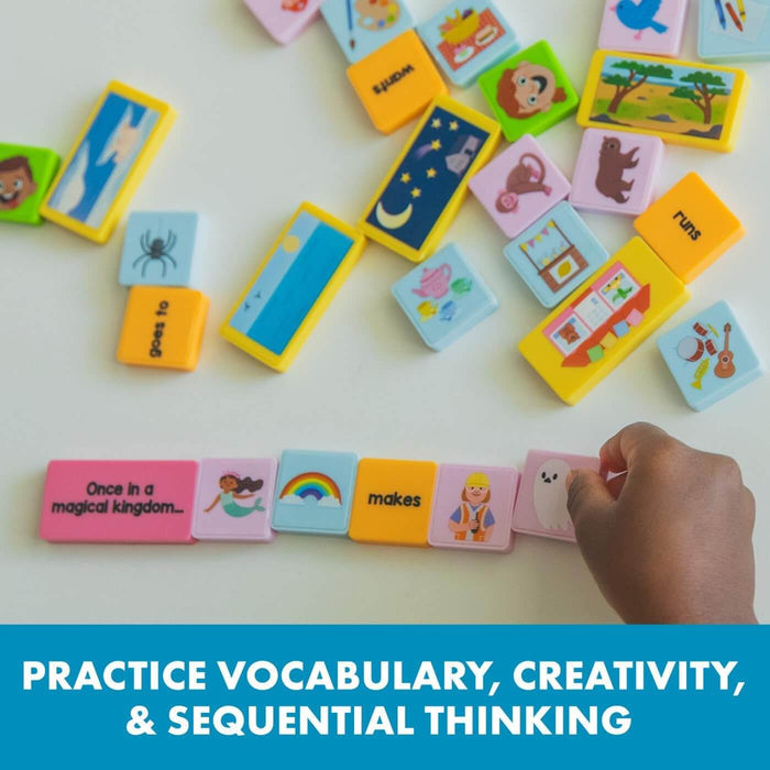 Hand arranging colorful domino tiles with words and pictures like a mermaid and rainbow into a story sequence.