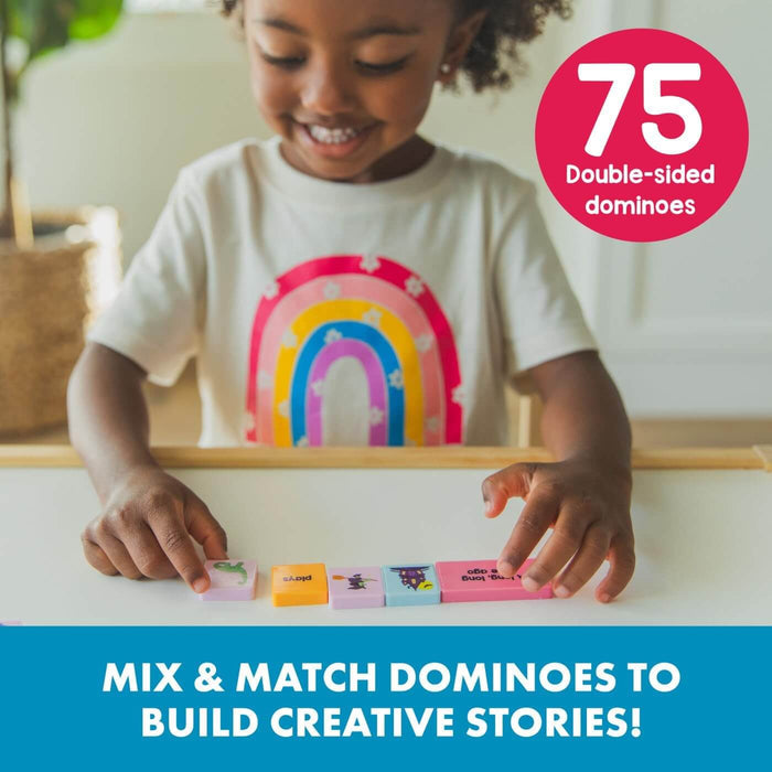 A smiling child playing with colorful storytelling dominoes featuring words and illustrations on a table.