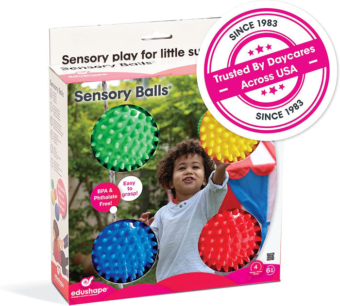Box of four bumpy, colorful sensory balls in green, yellow, blue, and red, featuring a young child playing.
