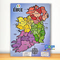 Wooden jigsaw puzzle map of Ireland with colorful counties and Irish labels, shown in clear plastic packaging.