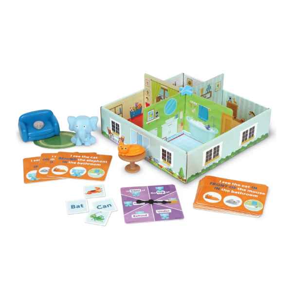 Educational game featuring a 3D cardboard house, blue elephant, orange cat, chair, spinner, and activity cards.