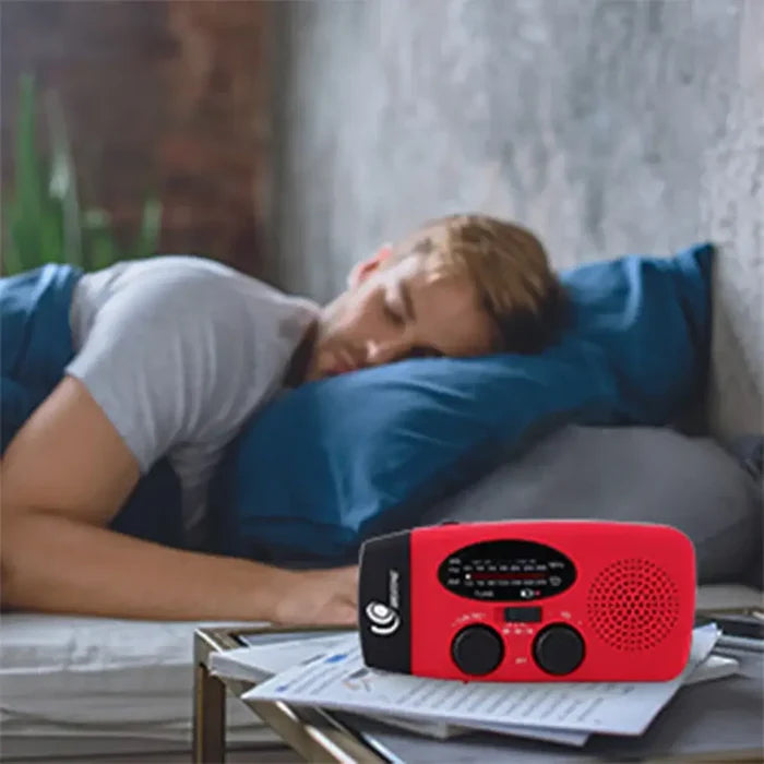 Emergency Radio with LED Lights Solar Charging Light shown on bedside table with a man sleeping in the background