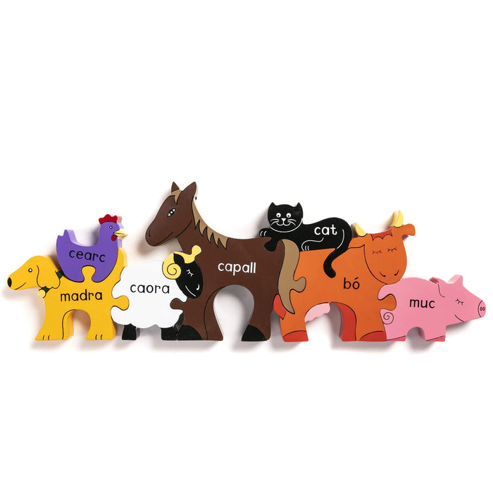 Multi-colored wooden farm animal jigsaw pieces with Irish names, arranged in a row against a plain white background.