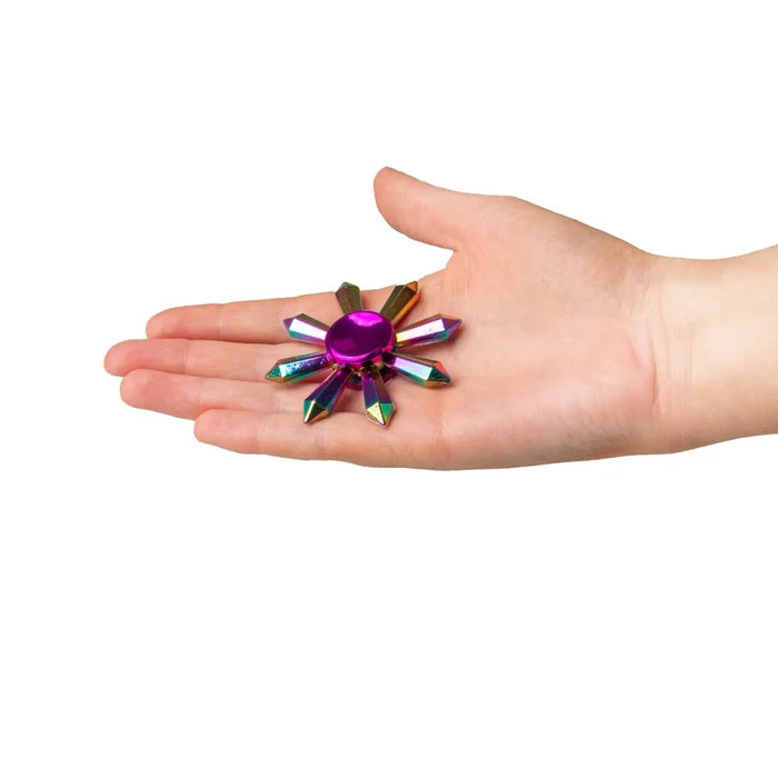 Iridescent 8-point star metallic fidget spinner held in an open palm against a white background.